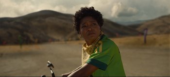 Movie still from “Nope” (2022), directed by Jordan Peele – A person on a bike in the middle of a road; Close Up shot, Over the shoulder angle