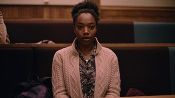 Movie still from “The End of the F***ing World” (2017), directed by Jonathan Entwistle – A person sitting in a courtroom with a book bag; Medium shot, Low angle