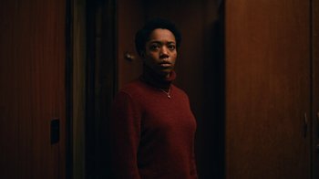 Movie still from “The End of the F***ing World” (2017), directed by Jonathan Entwistle – A woman in a red sweater standing next to a door; Medium shot, Low angle