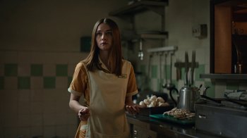 Movie still from “The End of the F***ing World” (2017), directed by Jonathan Entwistle – A woman in an apron standing in front of a counter; Medium shot, Over the shoulder angle