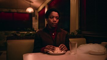 Movie still from “The End of the F***ing World” (2017), directed by Jonathan Entwistle – A person sitting at a table with a plate of food; Medium shot, Low angle