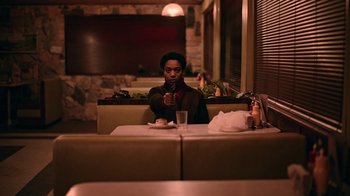 Movie still from “The End of the F***ing World” (2017), directed by Jonathan Entwistle – A person sitting at a table in a restaurant; Medium shot, Over the shoulder angle