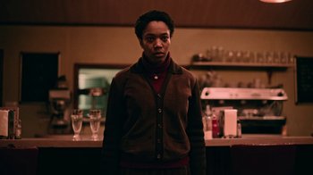 Movie still from “The End of the F***ing World” (2017), directed by Jonathan Entwistle – A person standing in a room with glasses on the counter; Medium shot, Low angle