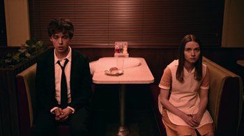 Movie still from “The End of the F***ing World” (2017), directed by Jonathan Entwistle – A man and a woman sitting at a table in front of a sandwich; Medium shot, High angle