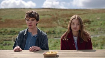 Movie still from “The End of the F***ing World” (2017), directed by Jonathan Entwistle – A boy and a girl sitting at a picnic table; Medium shot, Over the shoulder angle