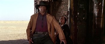Movie still from “Once Upon a Time in the West” (1968), directed by Sergio Leone – A man and a woman dressed in western clothing; Medium shot, Low angle