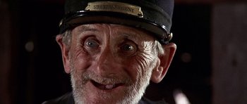 Movie still from “Once Upon a Time in the West” (1968), directed by Sergio Leone – An old man wearing a hat and smiling for the camera; Close Up shot, High angle