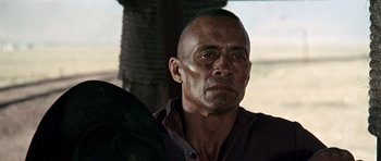 Movie still from “Once Upon a Time in the West” (1968), directed by Sergio Leone – An older man with a bald head is looking into the distance; Close Up shot, Over the shoulder angle