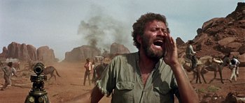 Movie still from “Once Upon a Time in the West” (1968), directed by Sergio Leone – A man is crying in the middle of the desert; Medium shot, Low angle