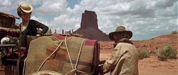 Movie still from “Once Upon a Time in the West” (1968), directed by Sergio Leone – A man riding on the back of a horse in the desert; Wide shot, Low angle