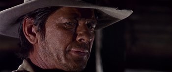 Movie still from “Once Upon a Time in the West” (1968), directed by Sergio Leone – A person wearing a cowboy hat; Close Up shot, Low angle