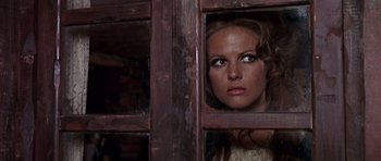 Movie still from “Once Upon a Time in the West” (1968), directed by Sergio Leone – A woman looking out of a wooden window; Close Up shot, Low angle