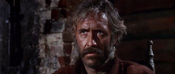 Movie still from “Once Upon a Time in the West” (1968), directed by Sergio Leone – An older man with a beard and a mustache; Close Up shot, Low angle