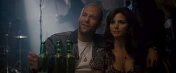 Movie still from “The Expendables 2” (2012), directed by Simon West – A man and a woman sitting next to each other; Close Up shot, Over the shoulder angle