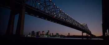 Movie still from “The Expendables 2” (2012), directed by Simon West – A view of a bridge with a city skyline in the background; Extreme Wide shot, Low angle