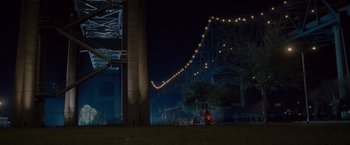 Movie still from “The Expendables 2” (2012), directed by Simon West – A view of a bridge lit up at night time; Extreme Wide shot, Low angle