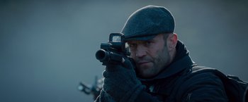 Movie still from “The Expendables 2” (2012), directed by Simon West – A man with a gun in his hands; Close Up shot, Low angle
