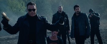 Movie still from “The Expendables 2” (2012), directed by Simon West – A group of men walking through a forest; Medium shot, Over the shoulder angle