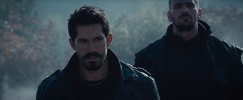 Movie still from “The Expendables 2” (2012), directed by Simon West – A man in a black jacket and a man in a black jacket; Close Up shot, Over the shoulder angle