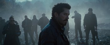 Movie still from “The Expendables 2” (2012), directed by Simon West – A group of men standing in a field; Close Up shot, Over the shoulder angle