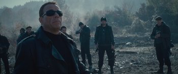 Movie still from “The Expendables 2” (2012), directed by Simon West – A group of men standing next to each other on top of a hill; Medium shot, Over the shoulder angle