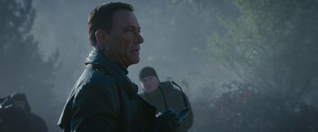 Movie still from “The Expendables 2” (2012), directed by Simon West – A man in a leather jacket holding a pair of sunglasses; Close Up shot, Over the shoulder angle