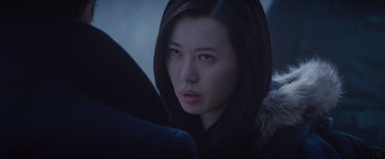 Movie still from “The Expendables 2” (2012), directed by Simon West – A person wearing a hooded jacket; Close Up shot, Over the shoulder angle