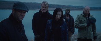 Movie still from “The Expendables 2” (2012), directed by Simon West – A group of people standing next to a body of water; Medium shot, High angle