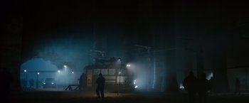 Movie still from “The Expendables 2” (2012), directed by Simon West – A man standing in front of a bus on a foggy night; Extreme Wide shot, Low angle