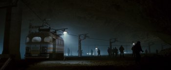 Movie still from “The Expendables 2” (2012), directed by Simon West – People are standing in a train station at night; Extreme Wide shot, High angle