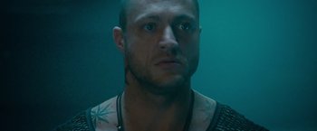 Movie still from “The Expendables 2” (2012), directed by Simon West – A person with a tattoo on his chest; Close Up shot, Low angle