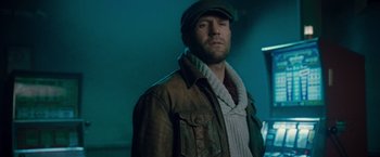 Movie still from “The Expendables 2” (2012), directed by Simon West – A man wearing a hat and a leather jacket; Close Up shot, Low angle