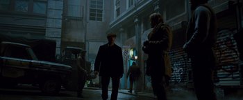 Movie still from “The Expendables 2” (2012), directed by Simon West – A group of people walking down a street at night; Wide shot, Low angle