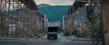 Movie still from “The Expendables 2” (2012), directed by Simon West – An old truck parked in the middle of an empty street; Extreme Wide shot, High angle