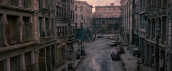 Movie still from “The Expendables 2” (2012), directed by Simon West – An empty city street with cars parked on the side of the road; Extreme Wide shot, High angle
