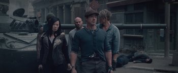 Movie still from “The Expendables 2” (2012), directed by Simon West – A group of people standing next to each other on a street; Medium shot, High angle
