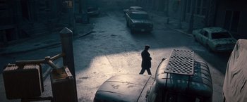 Movie still from “The Expendables 2” (2012), directed by Simon West – A man is walking on the sidewalk in the dark; Wide shot, High angle