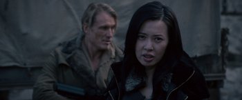 Movie still from “The Expendables 2” (2012), directed by Simon West – A man and a woman standing next to each other; Close Up shot, Over the shoulder angle