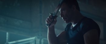 Movie still from “The Expendables 2” (2012), directed by Simon West – A person holding a sword; Close Up shot, Low angle