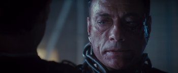 Movie still from “The Expendables 2” (2012), directed by Simon West – A man's face in a dark room; Close Up shot, Over the shoulder angle