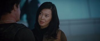 Movie still from “The Expendables 2” (2012), directed by Simon West – A person with long black hair; Close Up shot, Over the shoulder angle