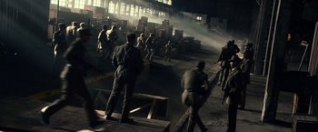 Movie still from “The Expendables 3” (2014), directed by Patrick Hughes – A group of men standing in an industrial setting; Extreme Wide shot, High angle