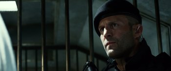 Movie still from “The Expendables 3” (2014), directed by Patrick Hughes – A person wearing a hat and looking to his left; Close Up shot, Low angle
