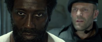 Movie still from “The Expendables 3” (2014), directed by Patrick Hughes – A person with a black beard; Close Up shot, Over the shoulder angle