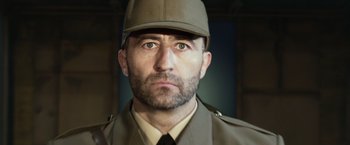 Movie still from “The Expendables 3” (2014), directed by Patrick Hughes – A person wearing a uniform and a hat; Close Up shot, Low angle