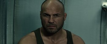 Movie still from “The Expendables 3” (2014), directed by Patrick Hughes – A man with a bald head and a black tank top; Close Up shot, Low angle
