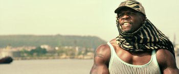 Movie still from “The Expendables 3” (2014), directed by Patrick Hughes – A person wearing a hat; Medium shot, Low angle