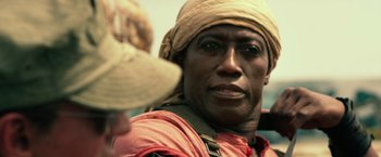 Movie still from “The Expendables 3” (2014), directed by Patrick Hughes – A person wearing a hat; Close Up shot, Over the shoulder angle
