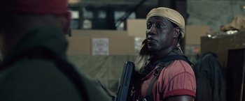 Movie still from “The Expendables 3” (2014), directed by Patrick Hughes – A man with a gun in his hand and wearing a hat; Close Up shot, Over the shoulder angle