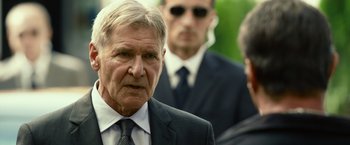 Movie still from “The Expendables 3” (2014), directed by Patrick Hughes – A person wearing a suit and tie; Close Up shot, Over the shoulder angle